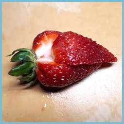 Une fraise dont un quartier est légèrement poussé vers le bas.