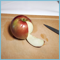Photo d’une pomme dans laquelle un quartier est tranché et écarté du cœur de la pomme. 