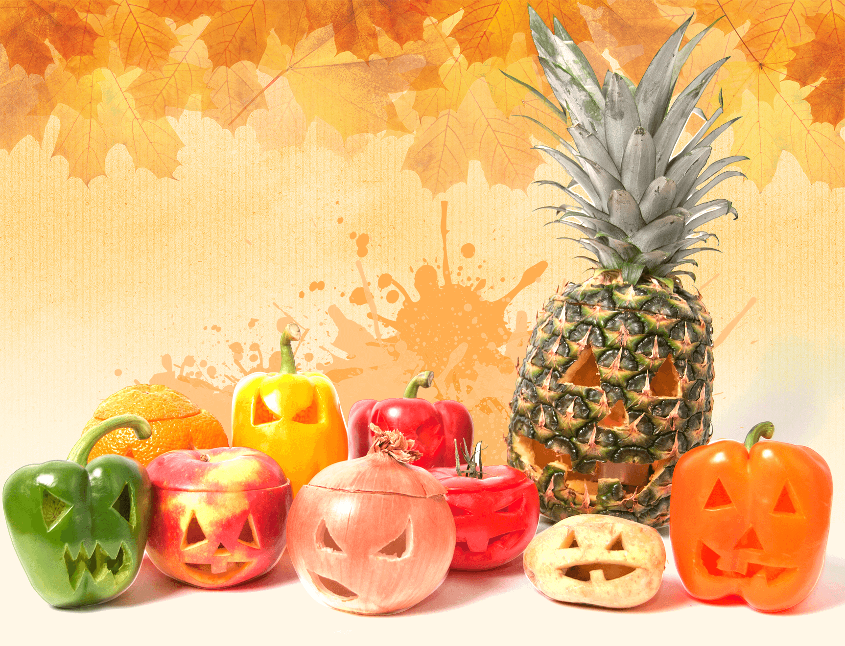 Photo de poivrons, oignons, pomme, tomate, pomme de terre et ananas dans lesquels un visage de citrouille d’Halloween est taillé. 