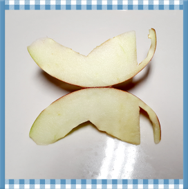 2 quartiers de pommes dos-à-dos qui sont coupés de façon à reproduire des ailes de papillon. 