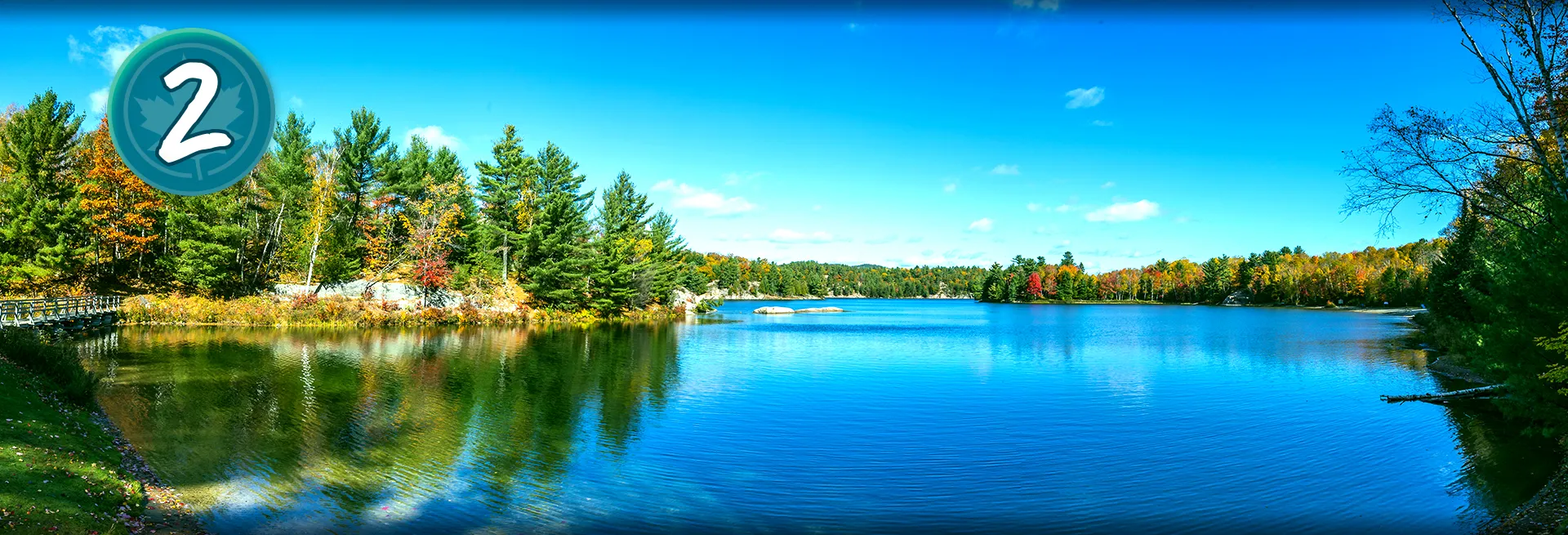 Photo d’un lac en automne. Cercle contenant le chiffre 2 et une feuille d’érable.