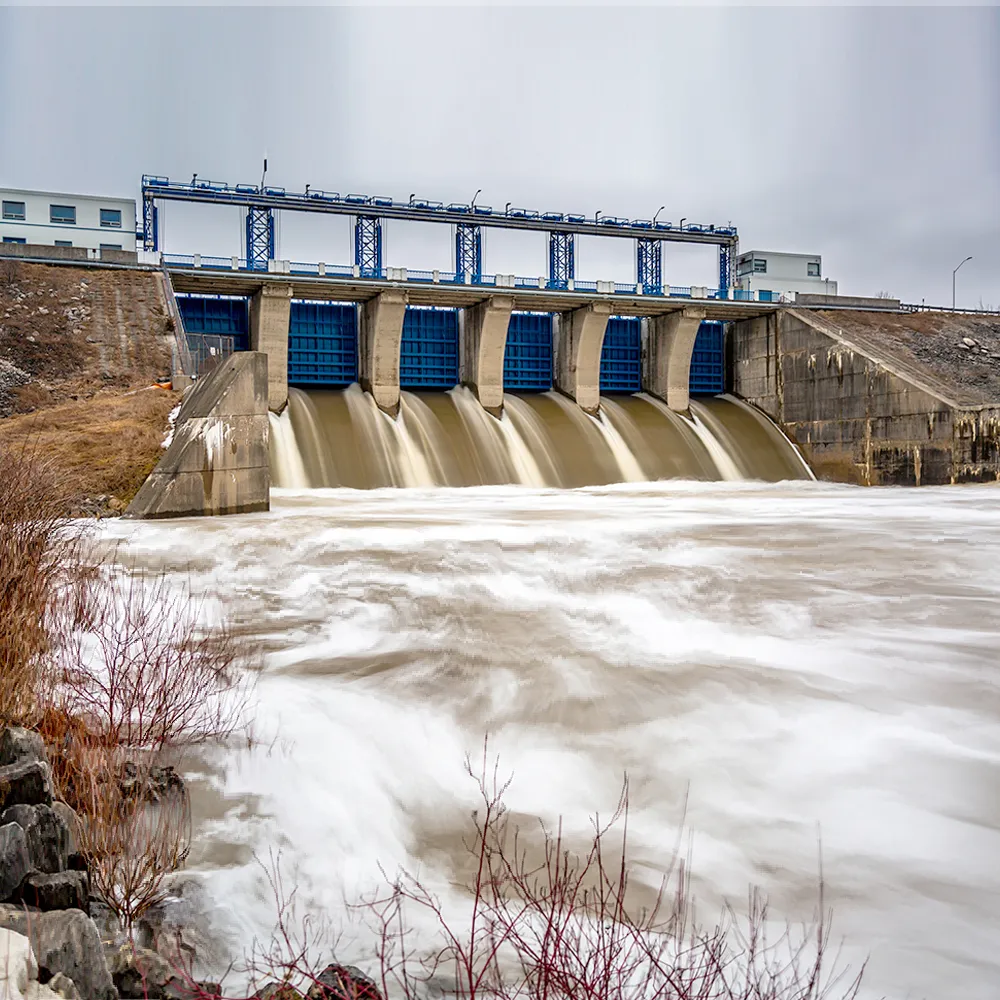 Photo d’un barrage hydroélectrique sous un ciel nuageux.