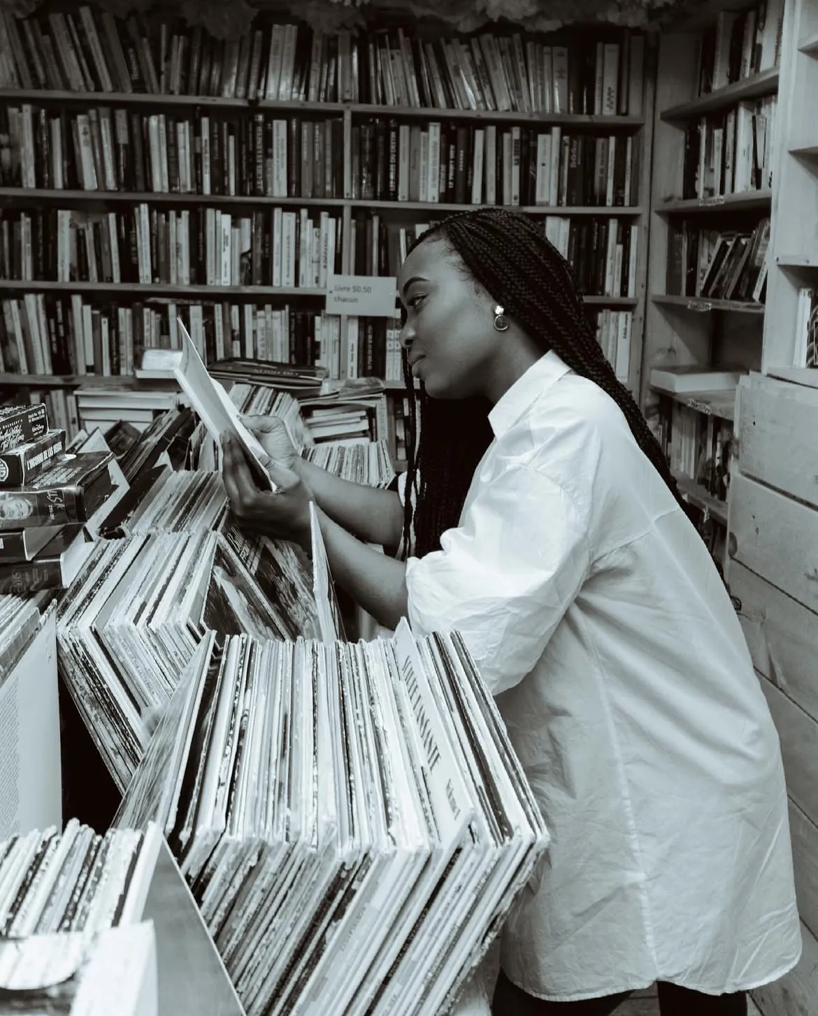 Photo de Christelle M. Kongolo, consultant un livre dans une bibliothèque.