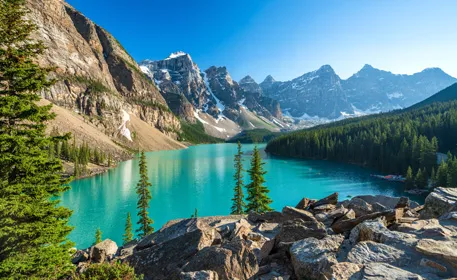 Photo d’un lac entouré de montagnes sous un ciel bleu.