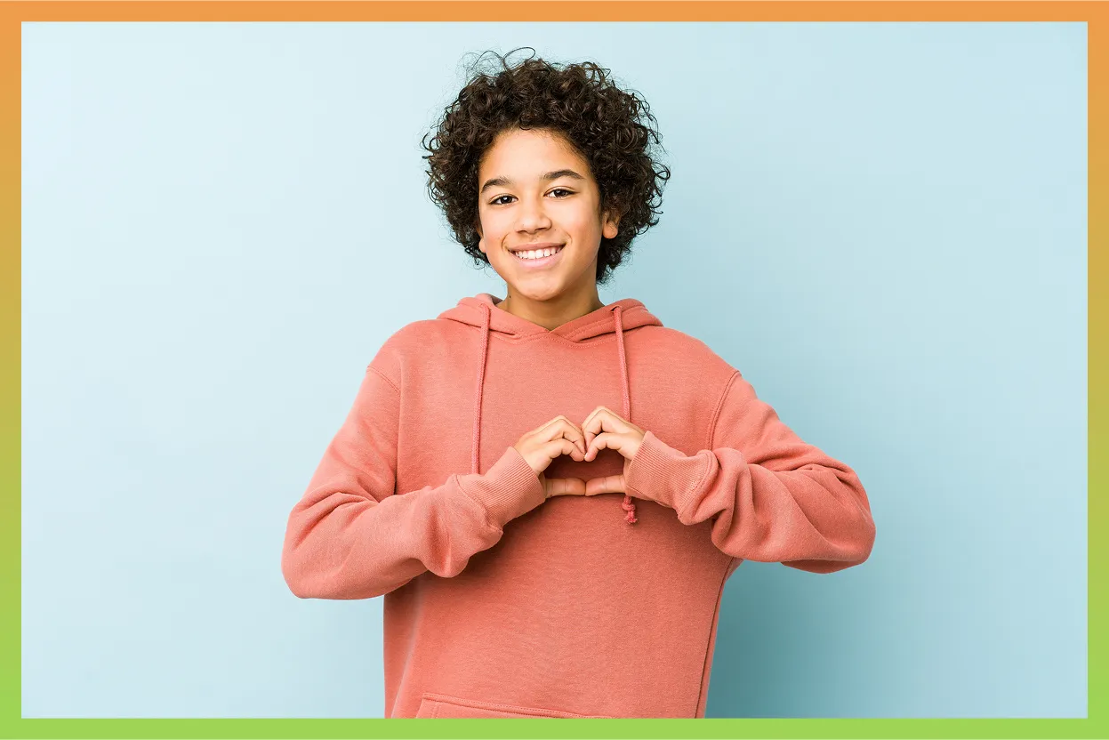 Un jeune qui a les mains jointes en forme de cœur.