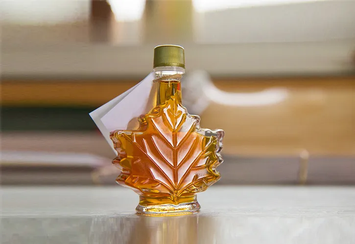 Photo d’une bouteille de sirop d’érable en forme de feuille.