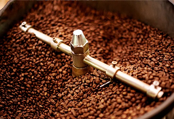 Photo de grains de café dans une machine de torréfaction.