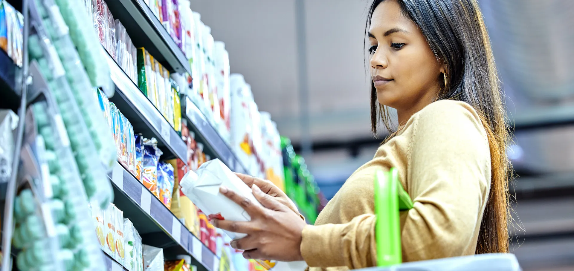 Photo d’une femme lisant l’étiquette d’un produit dans l’allée d’un magasin.