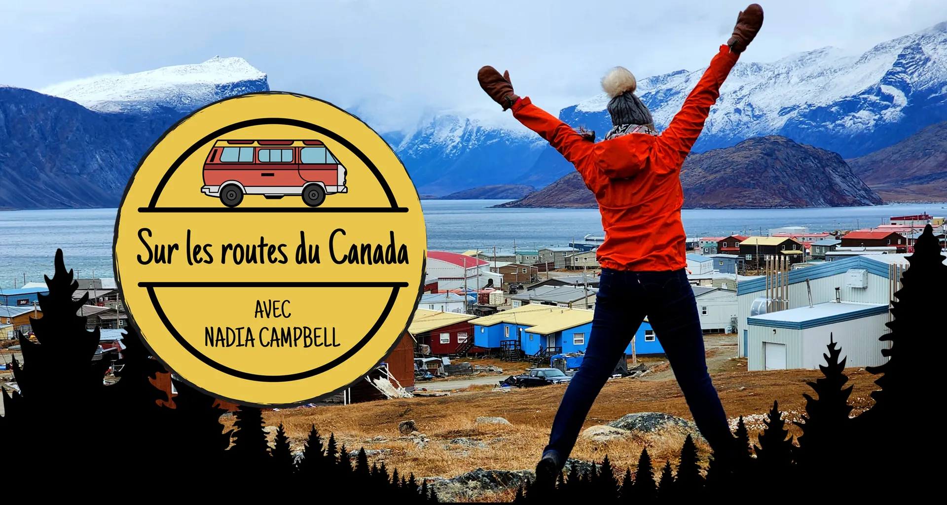 Photo de Nadia Campbell se tenant, les bras levés, devant un paysage de montagnes enneigé et d’un petit village près de l’eau.